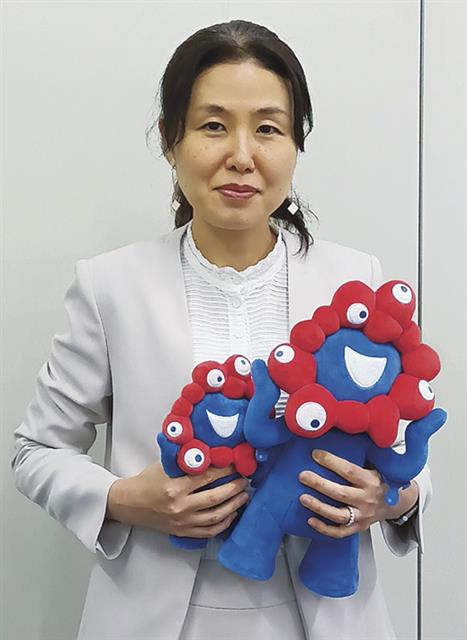 大阪・関西万博公式キャラクター・ミャクミャクのぬいぐるみを手にする五十嵐課長