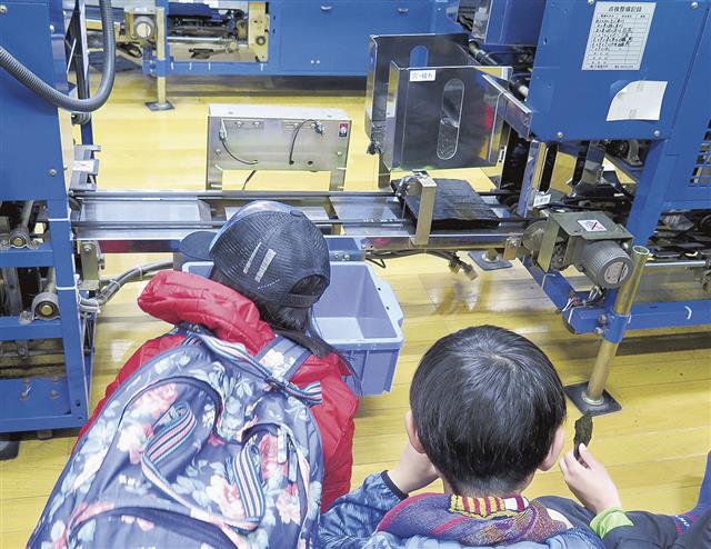 出来上がった板ノリを１０枚ずつ重ねて折り、結束する工程をひたすら見続ける子供もいた